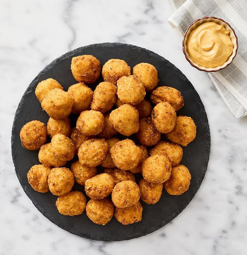 Generic Mac and Cheese Bites , Cavatappi pasta and a creamy, three-cheese filling coated in panko bread crumbs. Crispy